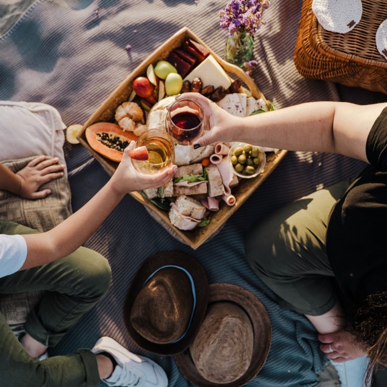 person holding brown wooden tray with food