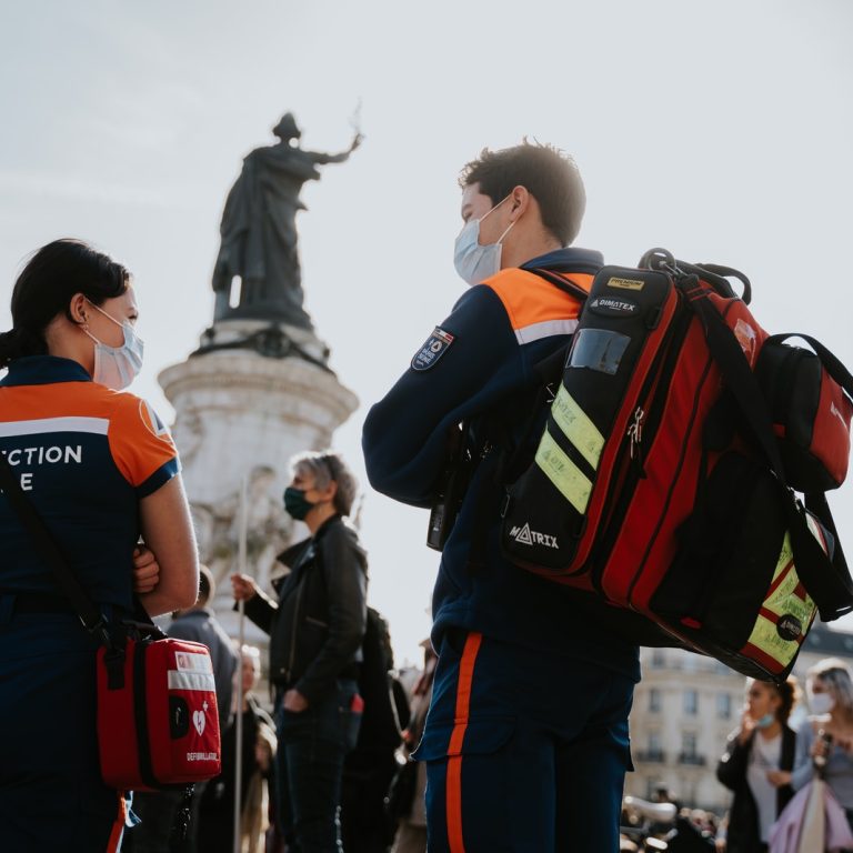 man in black and orange jacket carrying black and red backpack